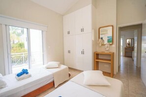 A hotel room with two beds, a large wardrobe, a mirror, and a view of the outdoors. - Seaview Villa Selenia pool & jacuzzi in Neo Chorio (Polis Chrysochous)