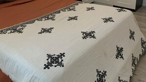Une chambre à coucher avec un lit, une lampe de chevet, une table de chevet et une armoire.