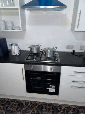 A kitchen with a gas stove, oven, and a coffee maker.