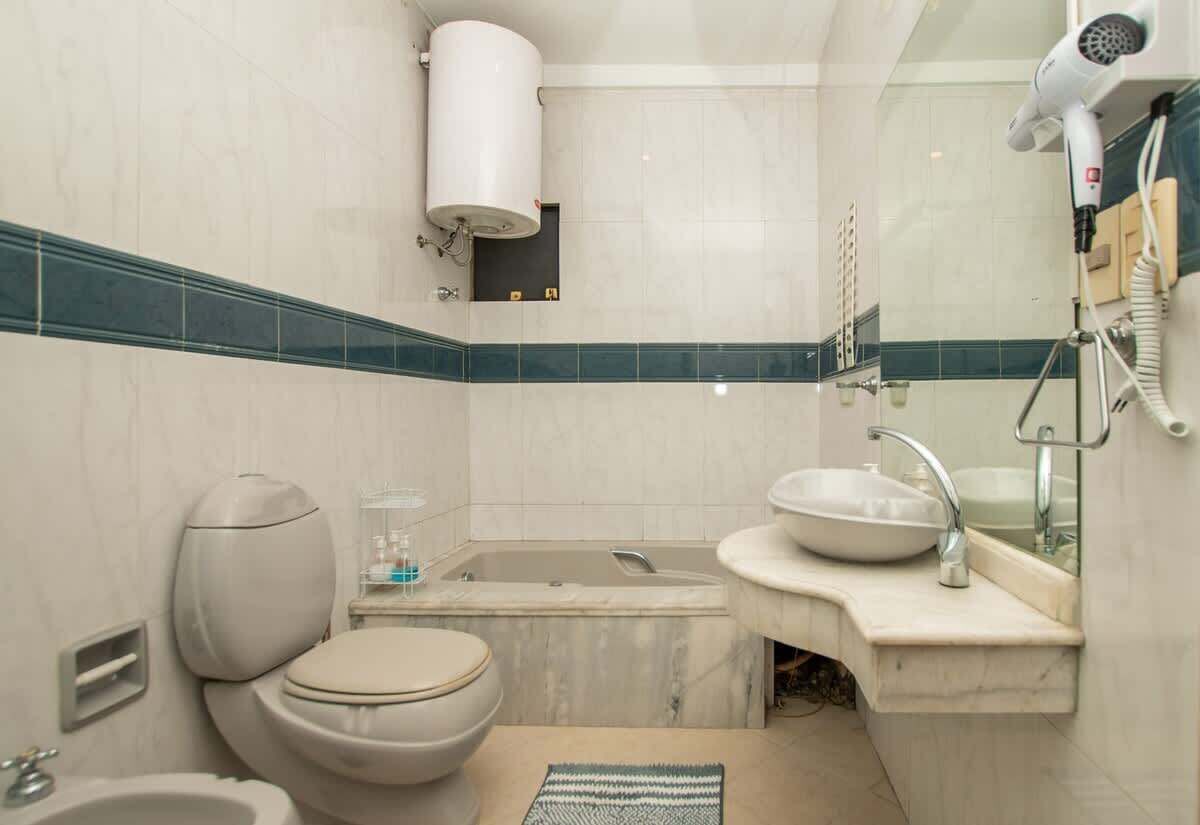 Un baño con inodoro, lavamanos y bañera.