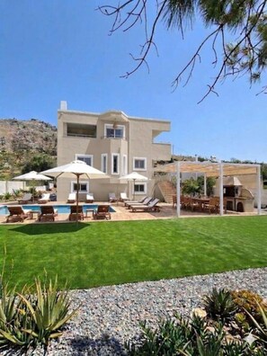 A modern two-story house with a swimming pool, outdoor seating, and a barbecue area. - Η Ιδανική Απόδραση στη Ρόδο Πολυτελής Βίλα Κοντά στη Θάλασσα με ιδιωτική πισίνα (Lardos Rhodes)