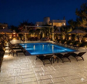 A swimming pool with lounge chairs, surrounded by a paved patio and outdoor seating area. - Η Ιδανική Απόδραση στη Ρόδο Πολυτελής Βίλα Κοντά στη Θάλασσα με ιδιωτική πισίνα (Lardos Rhodes)