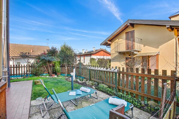 Un pati d'habitatge amb gespa verda i tanca de fusta.