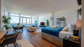 Une chambre d’hôtel moderne équipée d’un grand lit, d’un bureau, d’une chaise et d’un téléviseur.