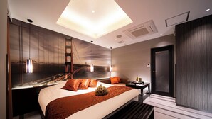 Una habitación de hotel moderna con una cama grande, una mesita de noche, un escritorio y vistas del Puente Golden Gate.
