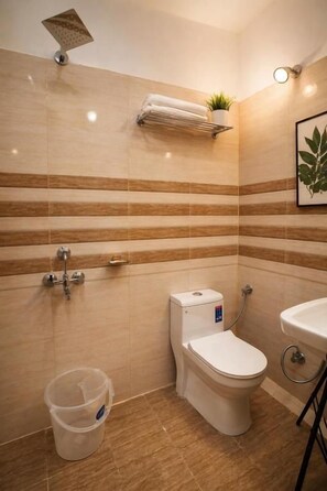 Une salle de bain avec des toilettes, un lavabo et une douche.