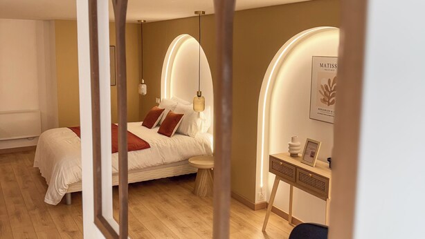Ein Schlafzimmer mit Bett, Nachttisch und Schreibtisch mit Stuhl.