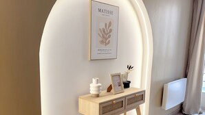 Ein Zimmer mit einem Holztisch, einem gerahmten Kunstwerk und einer Heizung.