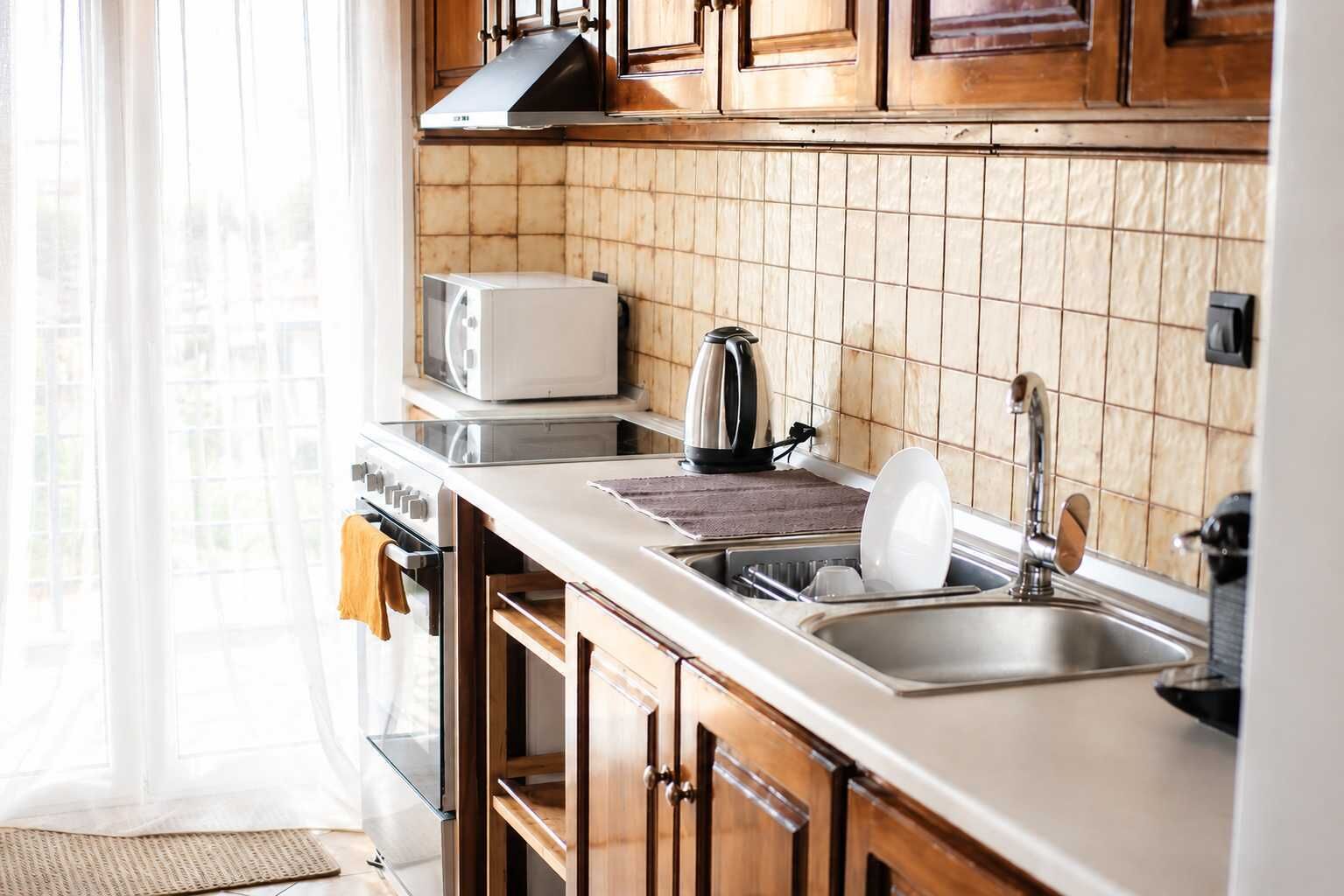 Una cocina moderna con microondas, hervidor y pileta.