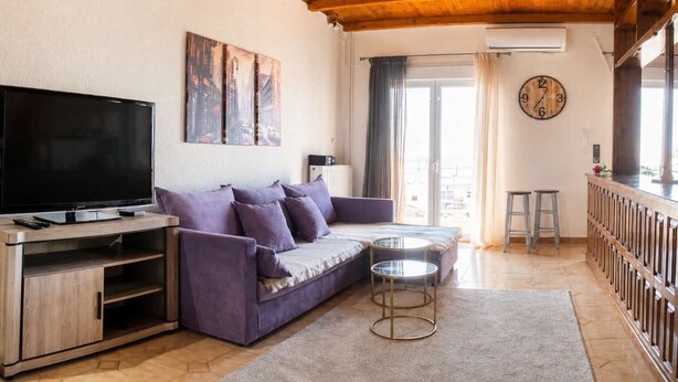 Una sala de estar con un sofá, televisor y una mesita.