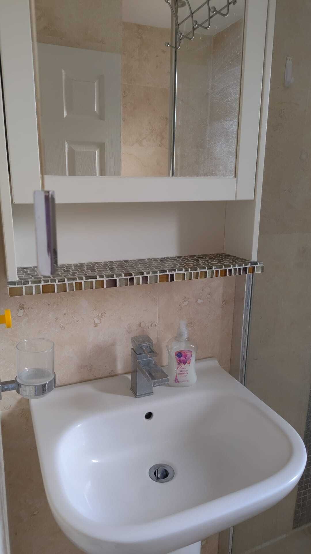 Een douche, handdoeken, zeep, toiletpapier
