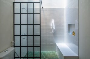 Une salle de bain avec une douche, des toilettes, une baignoire et une serviette accrochée au mur.