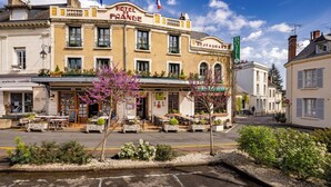Un hotel con restaurante, terraza y banderas.