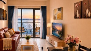 Una sala moderna con un sofá de cuero, una mesa de comedor con sillas, un televisor y un balcón con vistas.