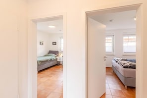 A bedroom with a bed, bedside table, and a window. - Südoase - Südoase - Modern vacation rental with a terrace and garden in a quiet location (Borkum)