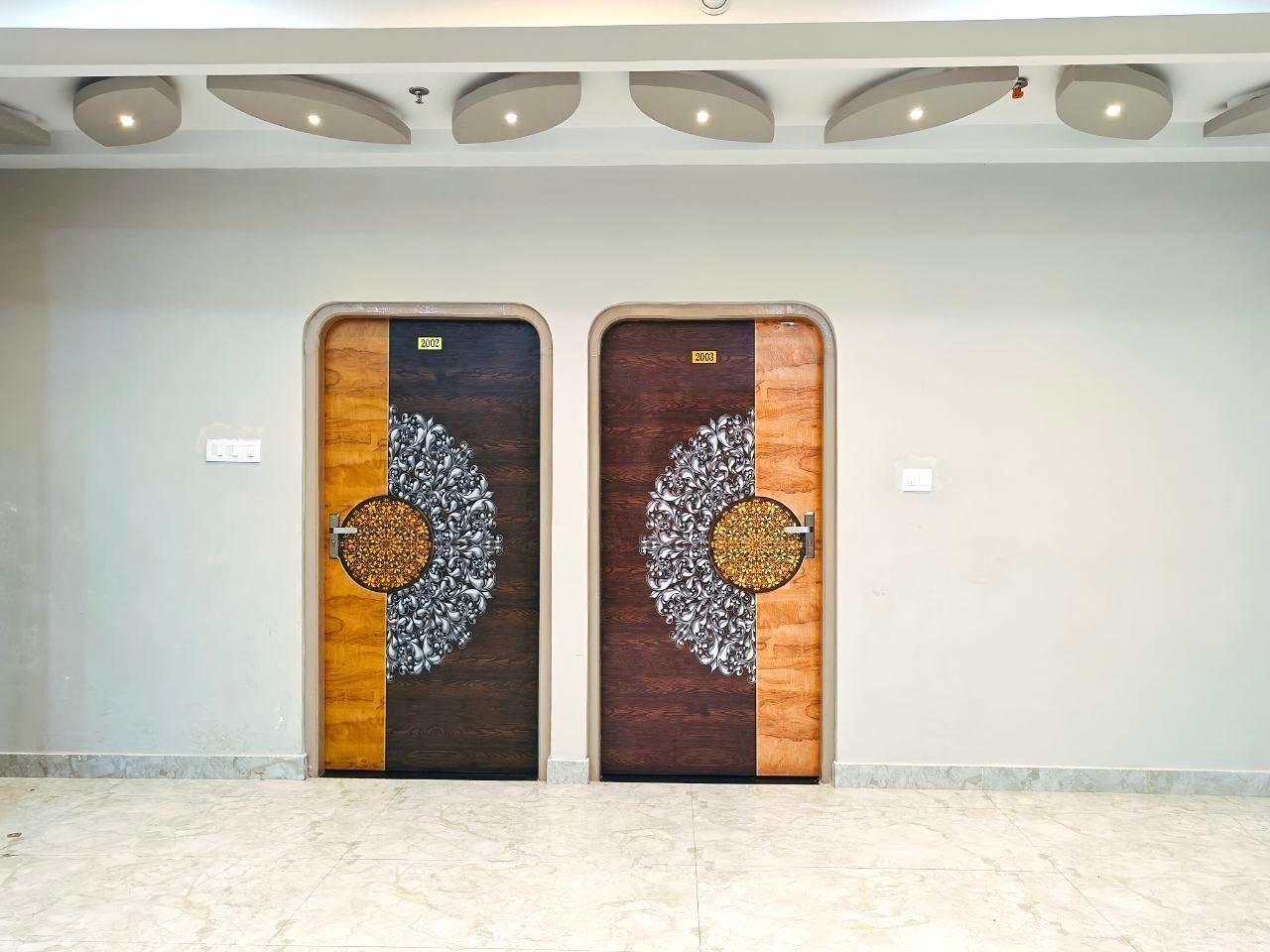Two wooden doors with intricate silver designs and a circular inset.