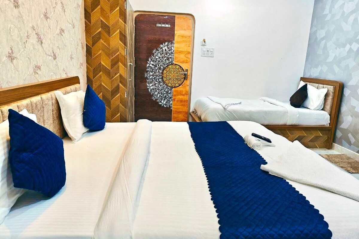 A hotel room with a large bed, a smaller bed, and a decorative door.
