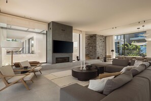 A modern living room with a fireplace, seating area, and large windows. - Eleven Sundays Retreat | Beach Escape by etouri (Chania)