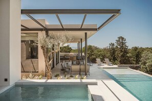 A modern outdoor pool area with a covered seating area, lounge chairs, and a view of the surrounding landscape. - Eleven Sundays Retreat | Beach Escape by etouri (Chania)