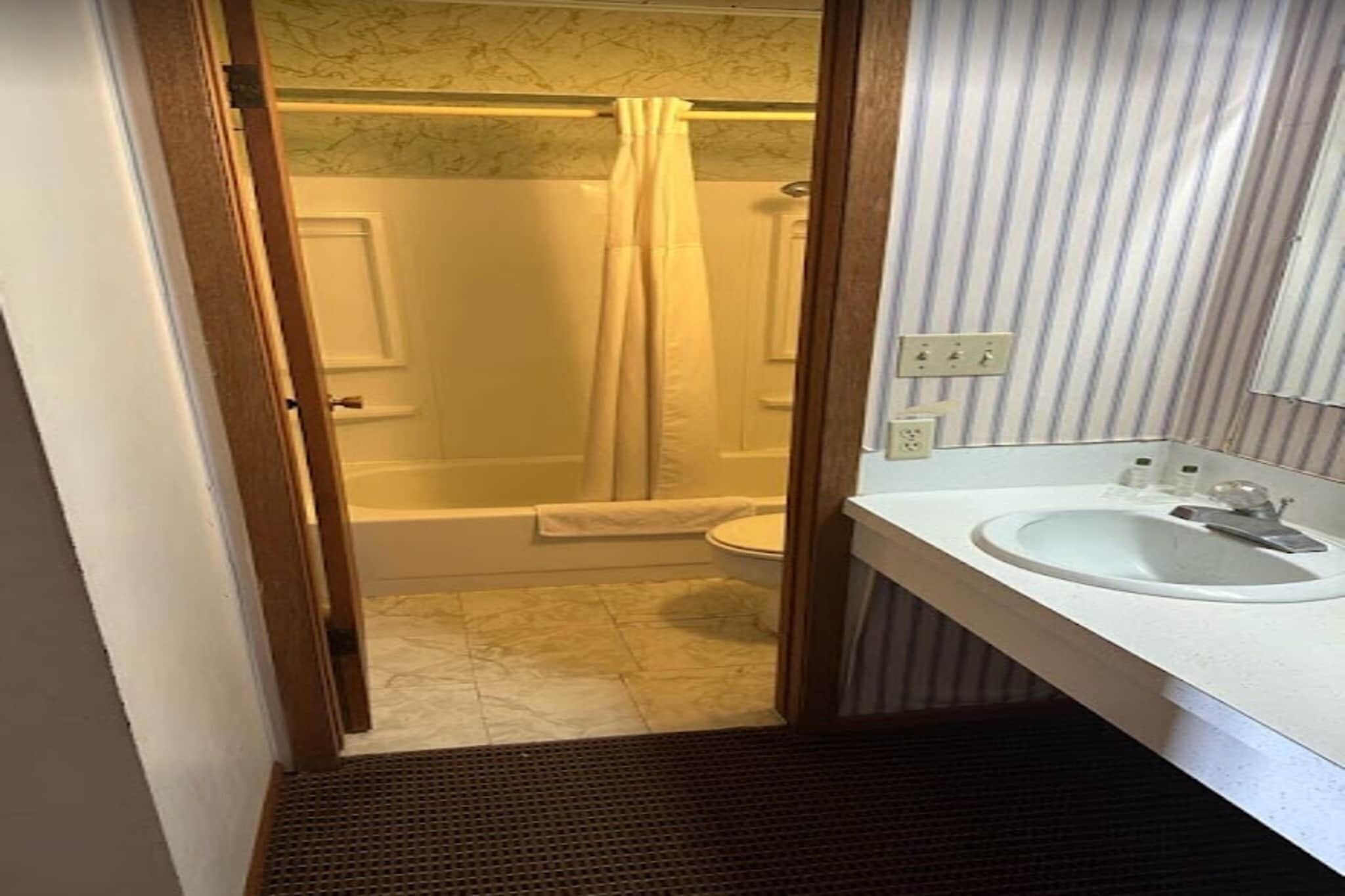 A bathroom with a shower, toilet, and sink.