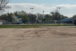 A sports field with a water slide, a covered pavilion, and street lamps. - Cozy Queen Bed | Alma NE (Alma NE)