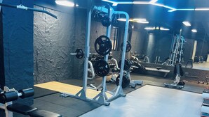 A gym with weightlifting equipment, benches, and a mirrored wall. - Luxury 2-bedroom, Modern Apartment, Elegant, Spacious in Kilimani Nairobi (Nairobi)