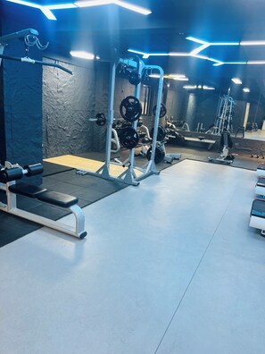 A gym with weightlifting equipment, benches, and a mirrored wall. - Luxury 2-bedroom, Modern Apartment, Elegant, Spacious in Kilimani Nairobi (Nairobi)