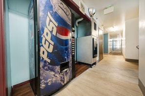 Käytävä, jossa on Pepsi-automaatti, mikroaaltouuni ja jääkaappi.