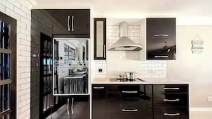 Una cocina moderna con armarios negros, una estufa de acero inoxidable y un ventanal.