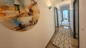 Un corridoio con un affresco a tema marittimo, un tappeto decorato e un'illuminazione curata.