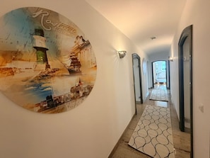 Un passadís amb un mural temàtic mariner, una catifes amb dibuixos i un interior ben il·luminat.