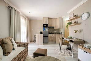 A modern kitchen with a refrigerator, microwave, and wooden cabinets. - Executive en-Suite, cozy, comfy and spacious (Johannesburg South)