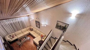A living room with a sofa, a coffee table, and a staircase. - The House at north of Bogota (Bogotá)