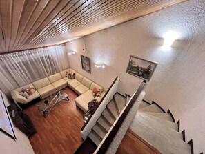 Ein Wohnzimmer mit einer Couch, einem Couchtisch und einer Treppe.