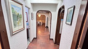 A hallway with white walls, framed pictures, and a wooden floor. - The House at north of Bogota (Bogotá)