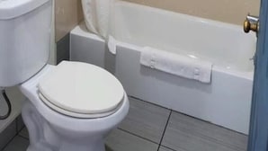 A bathroom with a toilet, a bathtub, and a shower curtain.