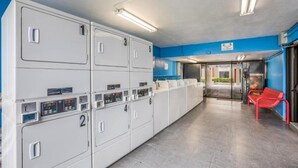 Una bugaderia amb rentamotos numerades, una banca i una entrada amb porta de vidre.