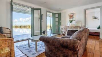 A spacious living area with a large window, a green door, and a view of a lake.