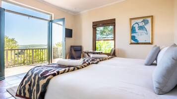 Un dormitorio con una cama grande, una silla, un televisor y un balcón con vistas.