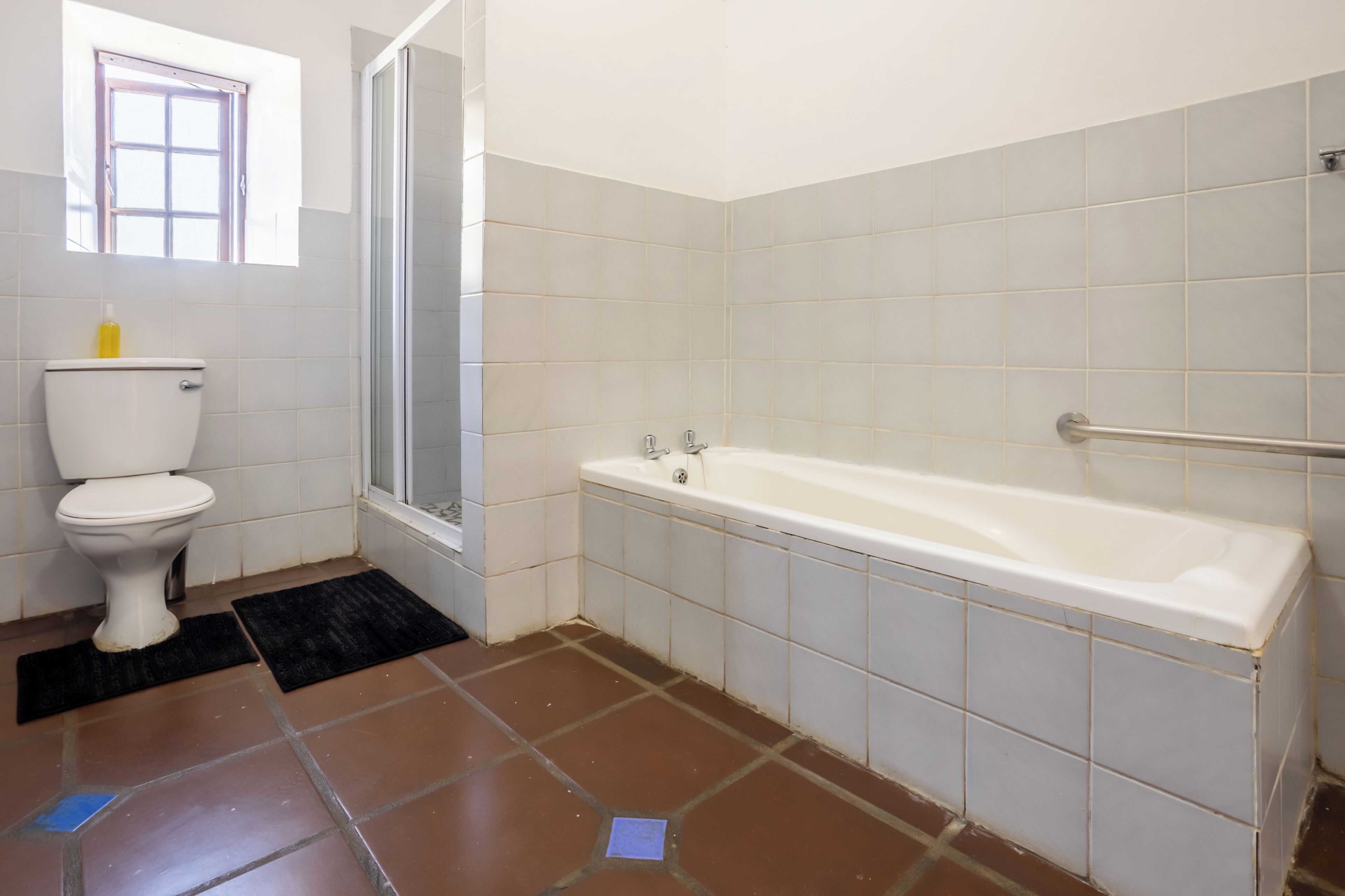 Une salle de bain équipée de toilettes, d’une baignoire et d’une douche.