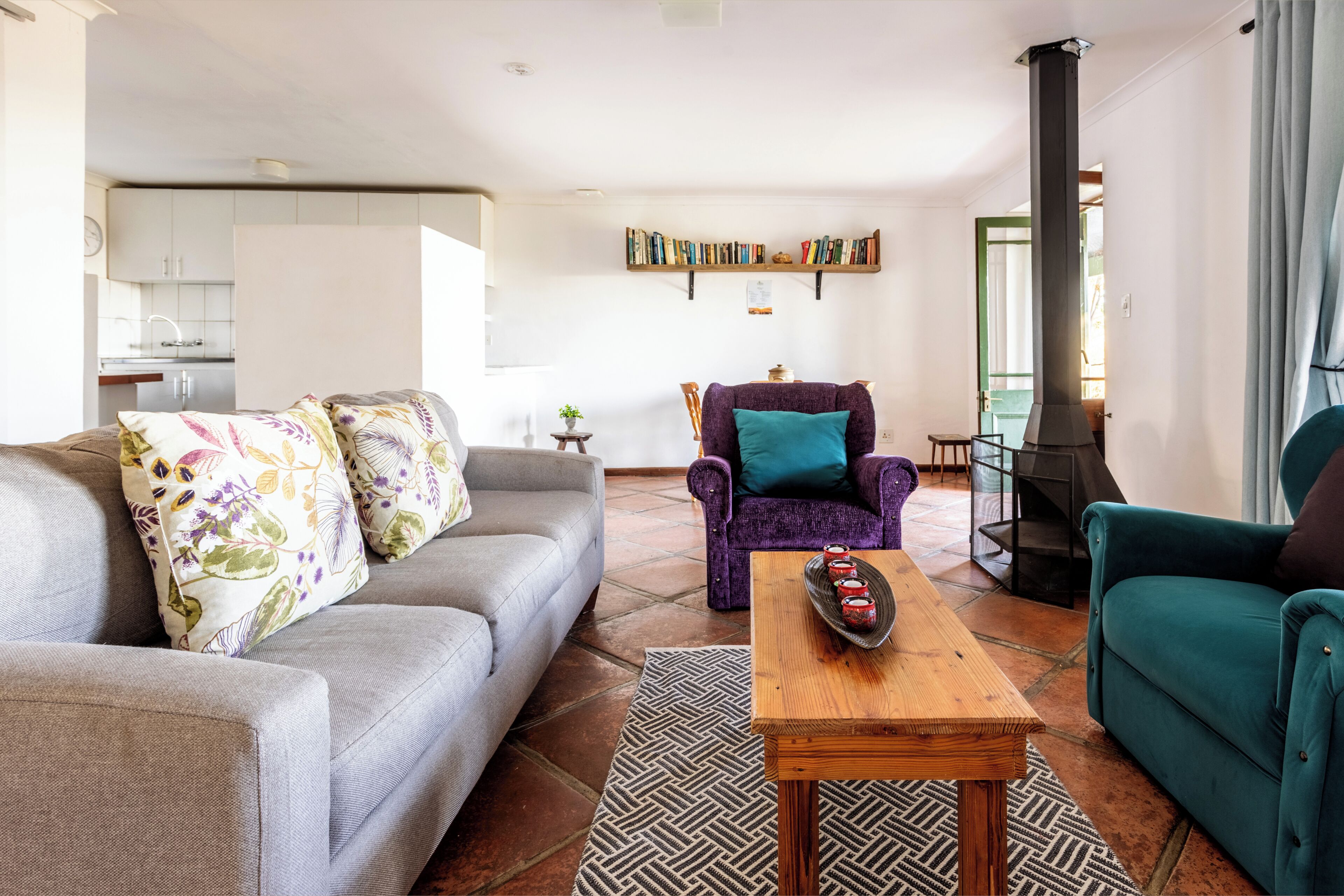 Una sala de estar con un sofá, sillones, una mesita de centro y una chimenea.