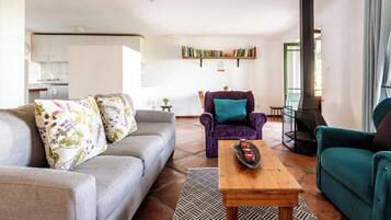 Una sala de estar con un sofá, sillones, una mesita de centro y una chimenea.