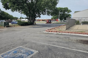 A parking lot with a Travel Inn sign, a tree, and a building in the background.
