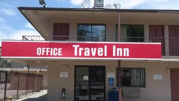 A building with a sign reading 'OFFICE Travel Inn' and a registration sign indicating 'Registration Parking Only.'
