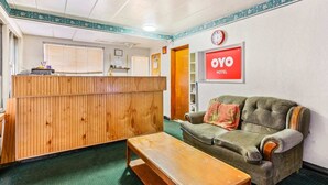 Un espace d’accueil avec un comptoir en bois, un canapé et un banc.