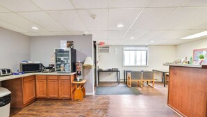 A kitchen area with wooden cabinets, a microwave, a coffee machine, and a small table with chairs. - Pipestone | 2 Full Bed (Pipestone)