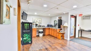 A kitchen with wooden cabinets, a refrigerator, a microwave, and a coffee maker. - Pipestone | 2 Full Bed (Pipestone)
