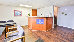 A reception desk with a sign for Pipestone Inn, a conference table, and a staircase. - Pipestone|King Bed|Nsmk (Pipestone)