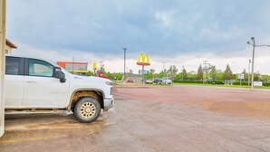 Un parking avec un camion blanc, un panneau McDonald's et un bâtiment en arrière-plan.