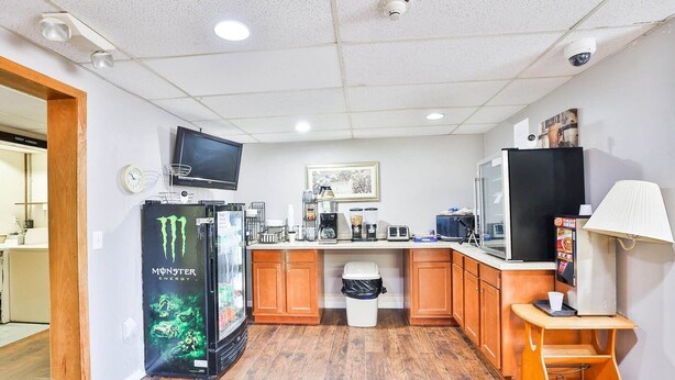 A compact kitchen with a refrigerator, microwave, coffee maker, and a flat-screen TV. - Pipestone|King Bed|Nsmk (Pipestone)